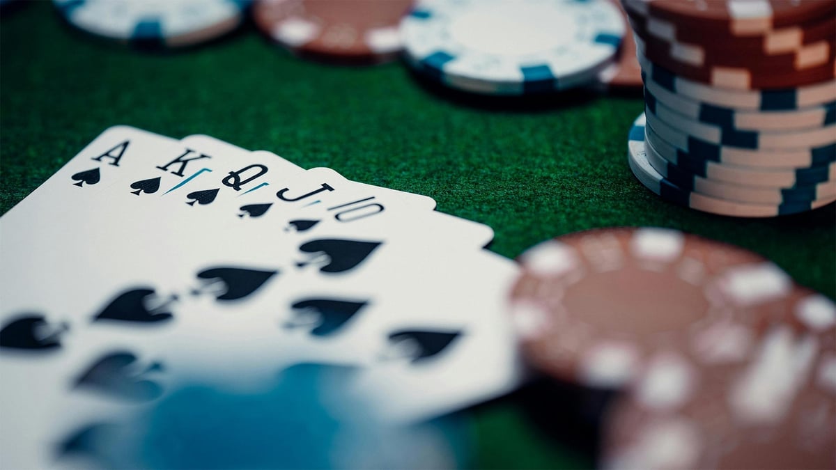 Ett pokerbord med spelmarker och en royal straight flush i spader.c