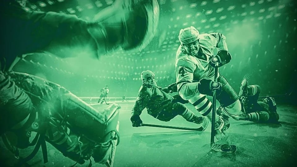 Intensiv ishockeyaction med spelare i närkamp om pucken, en målvakt i förgrunden och en ljussatt arena i bakgrunden, tonat i grönt.