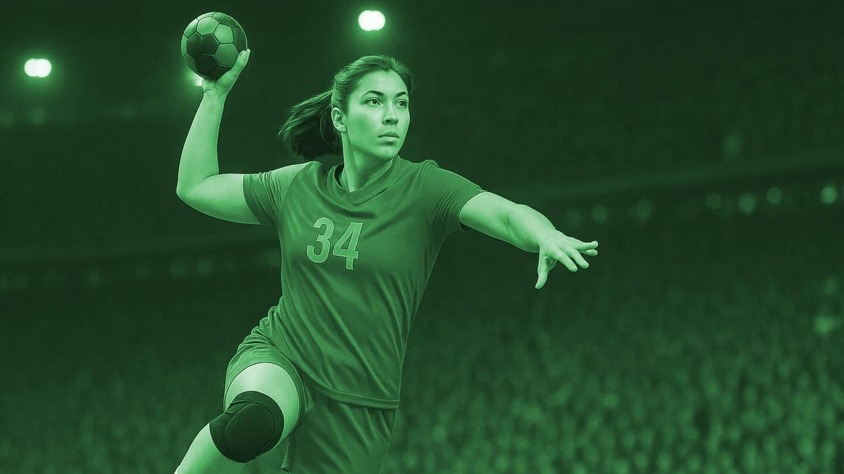 En handbollsspelare hoppar i luften, redo att göra mål.