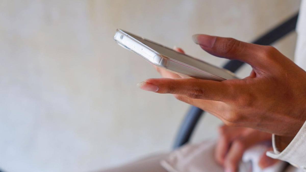 En person läser om spelhistorik hos Paf på mobilen.