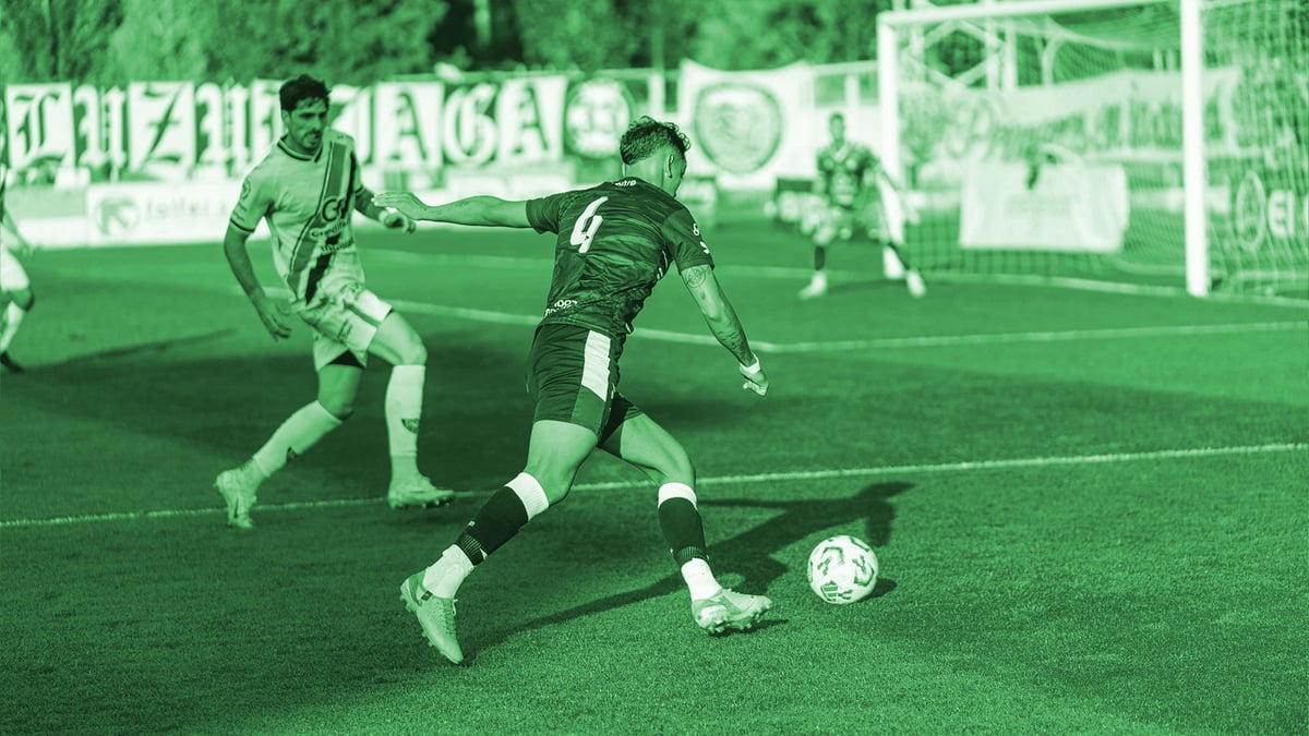 Två spelare som möter varandra i en intensiv fotbollsmatch.