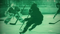 En ishockeyspelare åker mot mål med pucken, medan målvakten är redo att försvara.