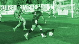 Två spelare som möter varandra i en intensiv fotbollsmatch.